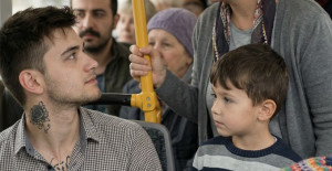 Otobüste, yanında iki çocuğu olan bir kadın ayakta bekliyordu